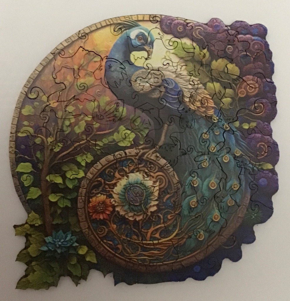 An illustration of a peacock with a vibrant tail, nestled among decorative floral swirls and a tree in a circular frame.