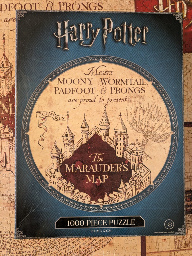 An illustration of the Marauder's Map featuring a stylized view of Hogwarts castle on parchment-colored circular background