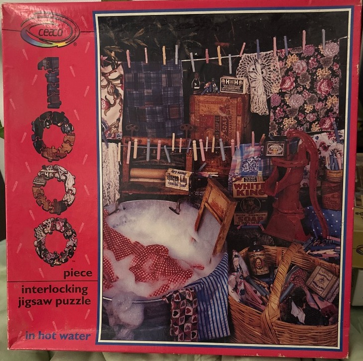 A nostalgic laundry scene with a metal tub full of soapy water, a washboard, drying clothes, and old-fashioned soap boxes.