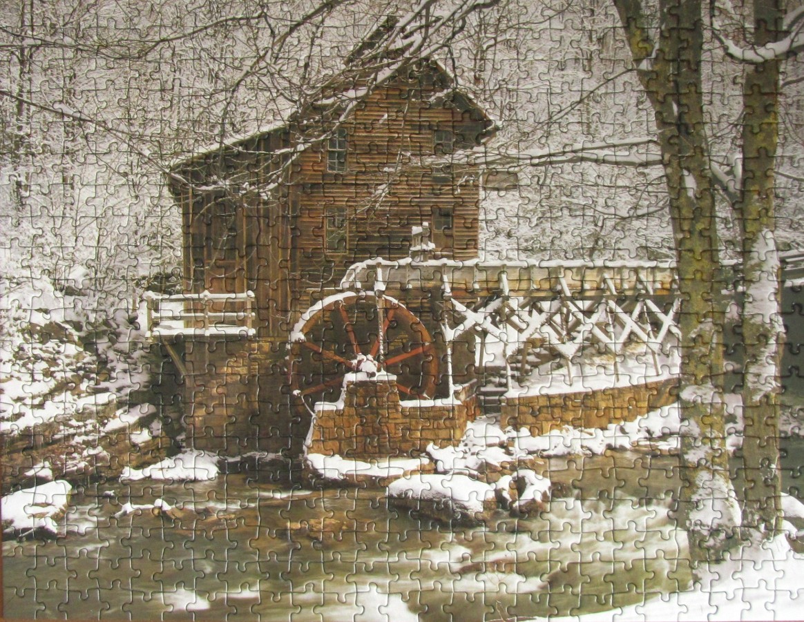 A rustic wooden water mill sits beside a stream in a tranquil, snowy winter forest scene.