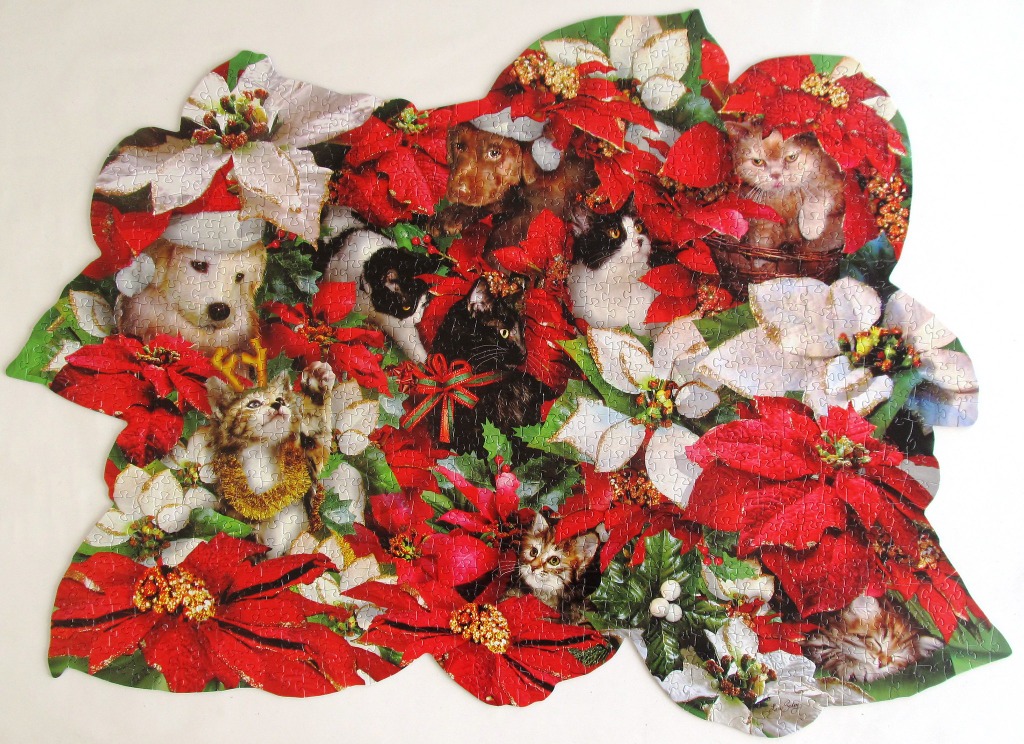 A whimsical holiday scene featuring several kittens and a puppy nestled among vibrant red and white poinsettia flowers.