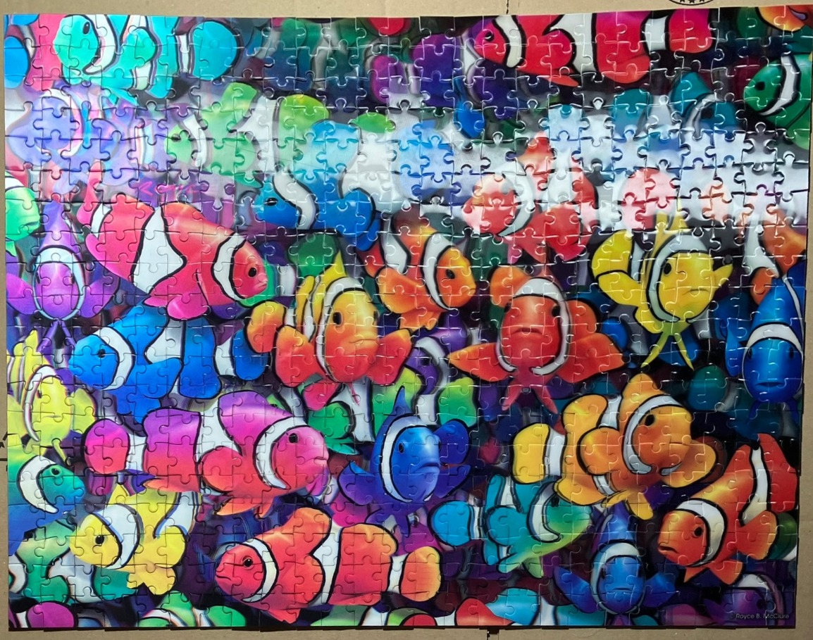 A densely packed pattern of colorful clownfish in various vibrant hues.