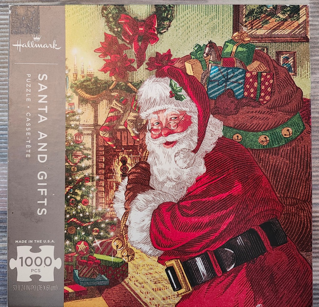 Santa Claus smiling warmly while carrying a large sack of colorful wrapped gifts in a cozy, decorated living room.