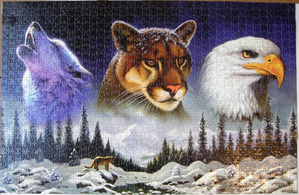 A composite image featuring a wolf, cougar, and bald eagle overlooking a snowy mountain landscape.