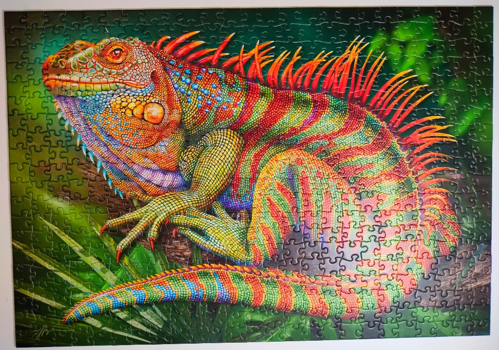 A vibrantly colored iguana with stripes and spikes perched on a branch against a blurred green forest background.