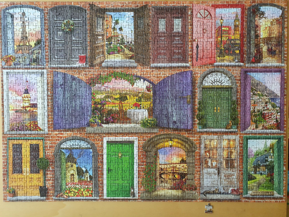 A collage of various colorful doors opening onto different scenic travel locations around the world.