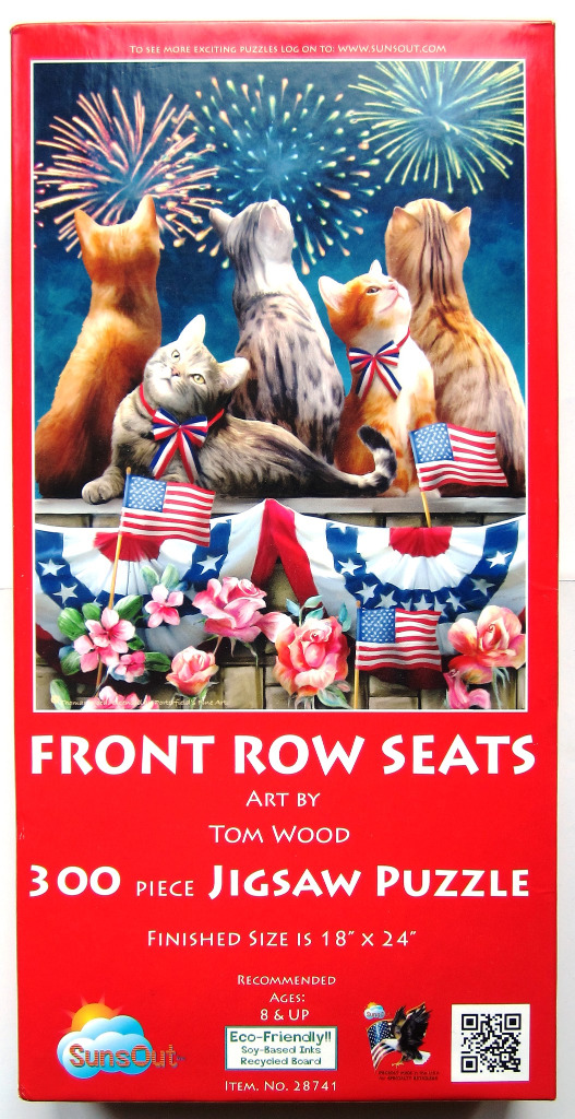 Four cats watching fireworks over an American flag-draped balcony.
