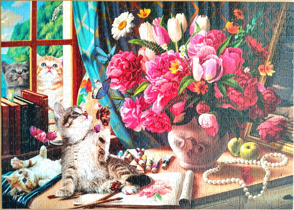 A whimsical illustration of three kittens playing with butterflies near a vase of pink flowers and art supplies.