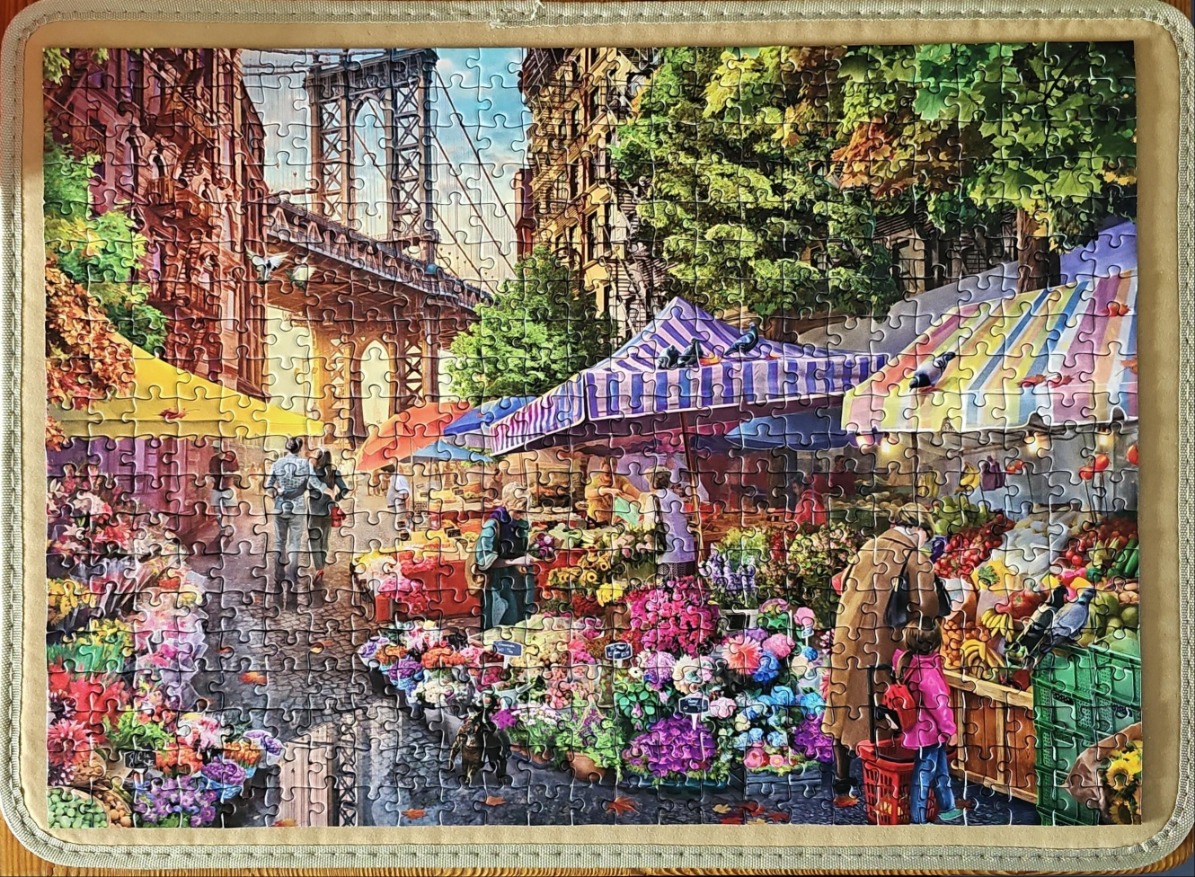 A lively street market scene in New York City with the Manhattan Bridge in the background.