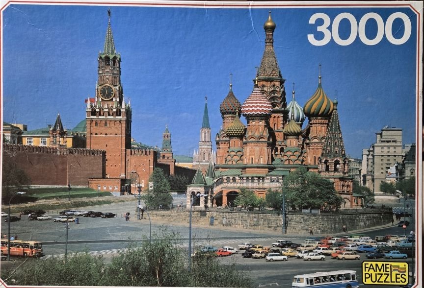 Saint Basil's Cathedral and Spasskaya Tower in Moscow under a bright blue sky.