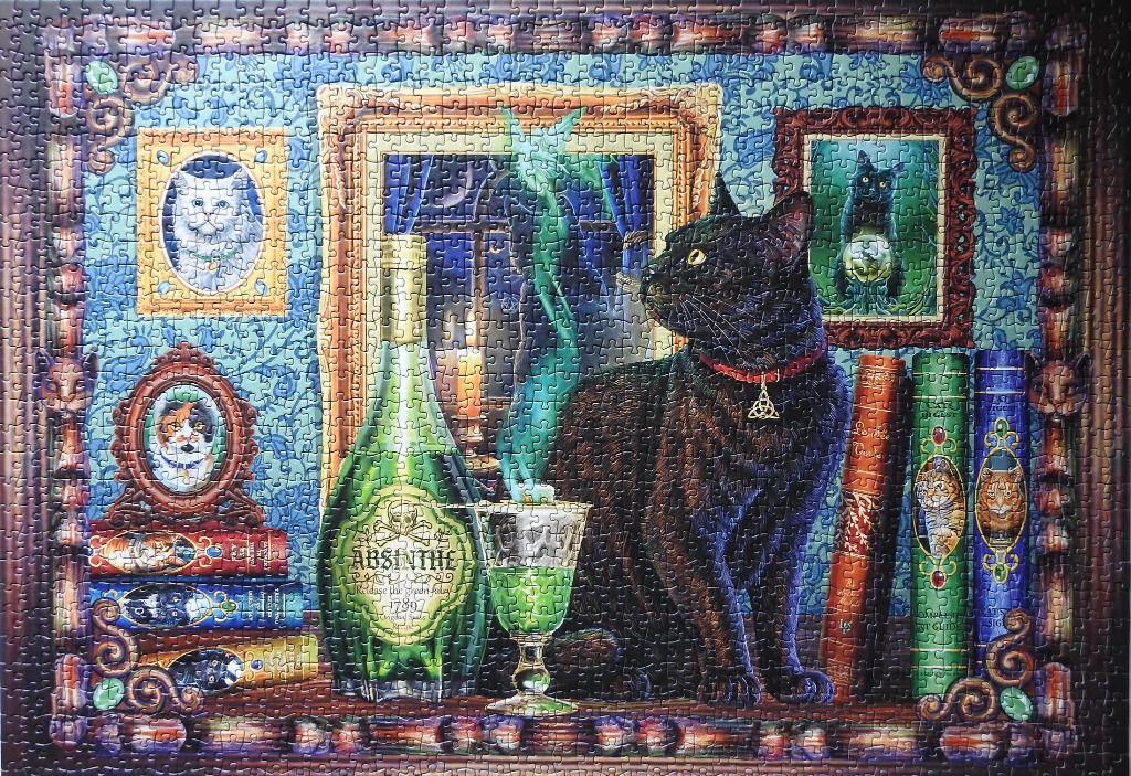 A black cat wearing a Celtic knot pendant sits beside an absinthe bottle and glass in a room decorated with cat portraits.