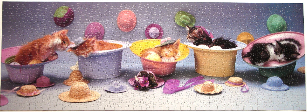 Six kittens nestled inside colorful hats against a purple backdrop with floating hats in the background.