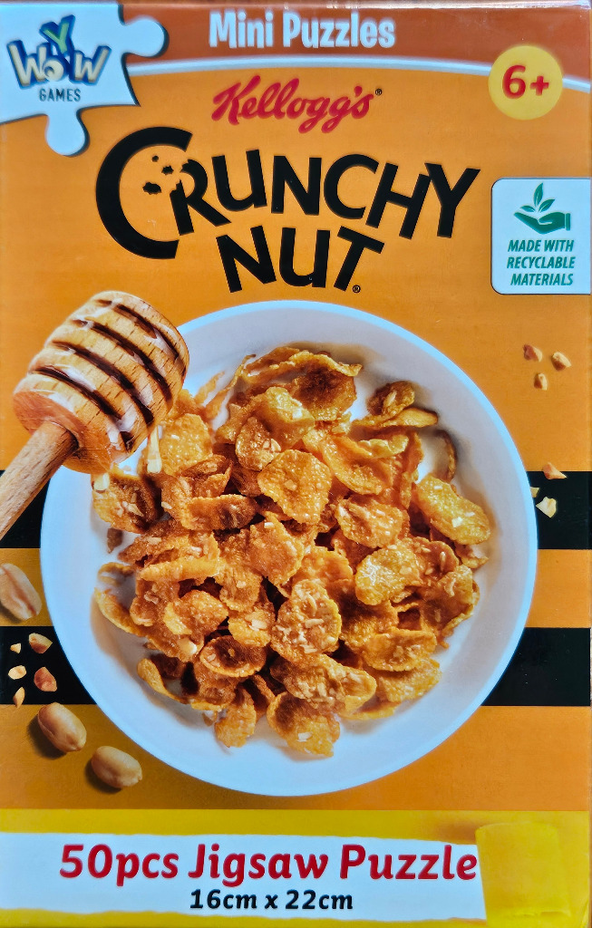 A bowl of golden-brown cereal flakes with a wooden honey dipper against an orange background.