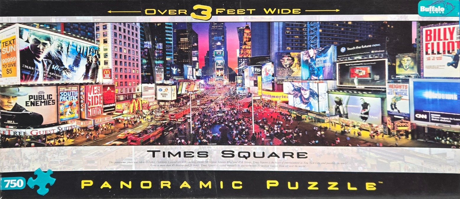 A panoramic photograph of Times Square in New York City at twilight, filled with vibrant advertising billboards.