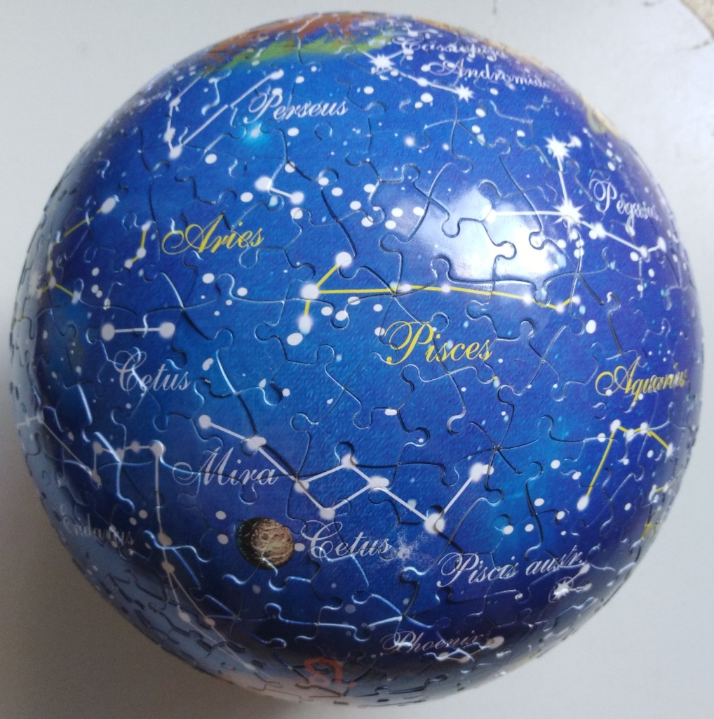 A spherical celestial map showing various constellations against a deep blue night sky.