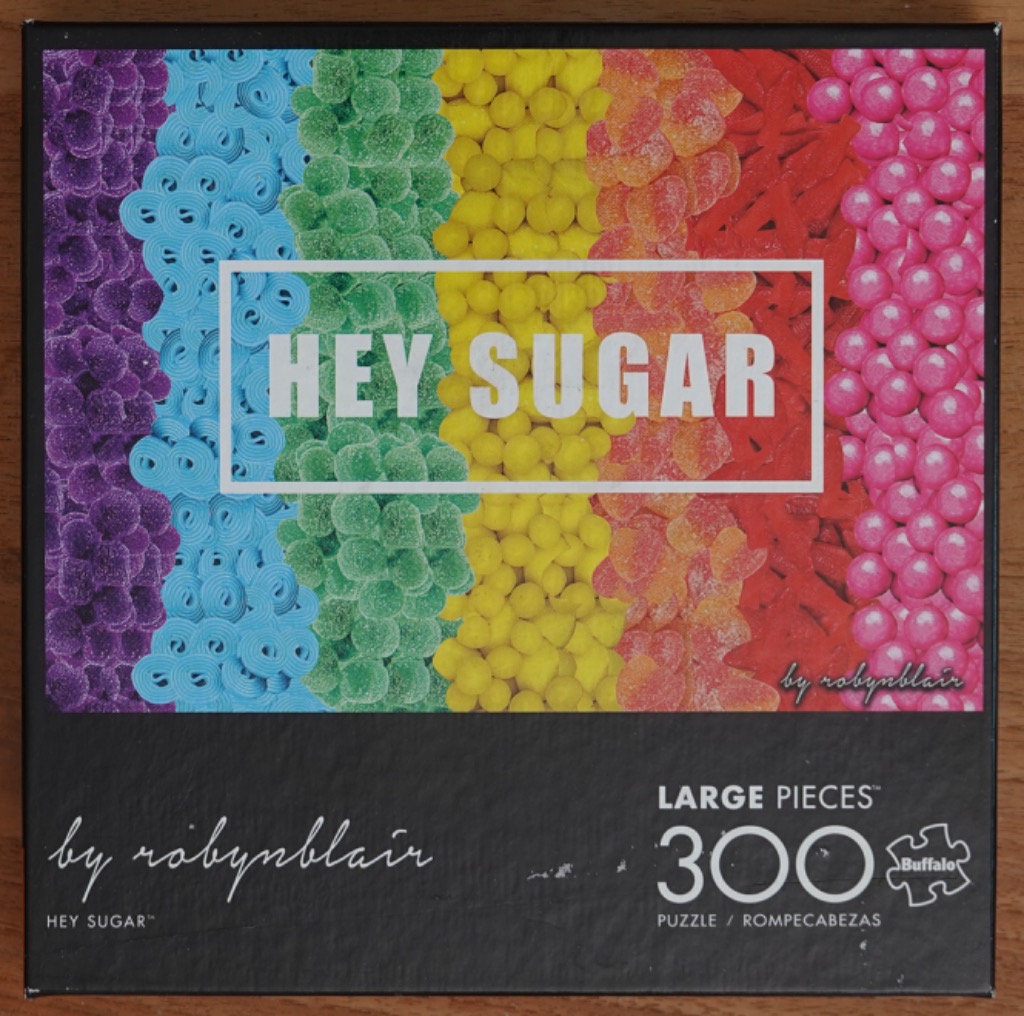 A vibrant rainbow arrangement of various colorful candies organized into vertical stripes.