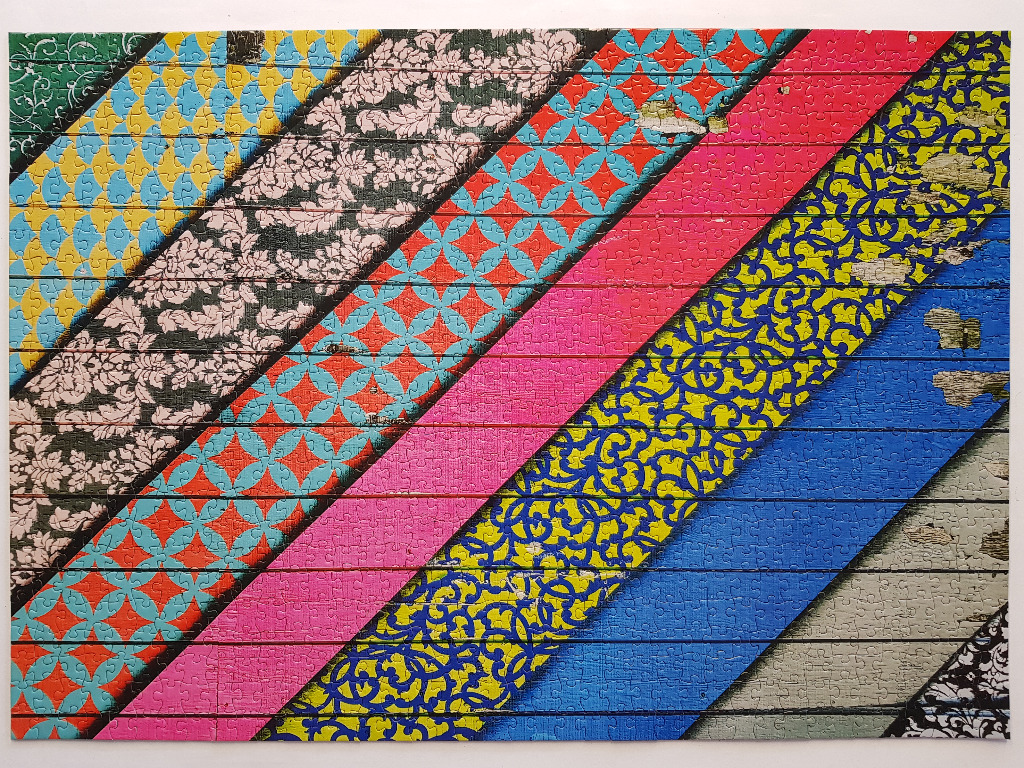 Abstract design of diagonal colorful strips with varied patterns and distressed wood texture.