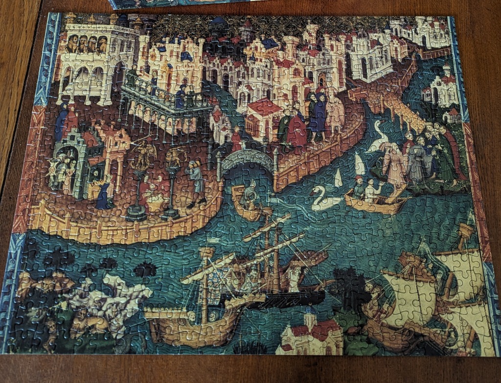 A medieval-style depiction of a bustling city and harbor with ships, boats, and figures in historical attire.