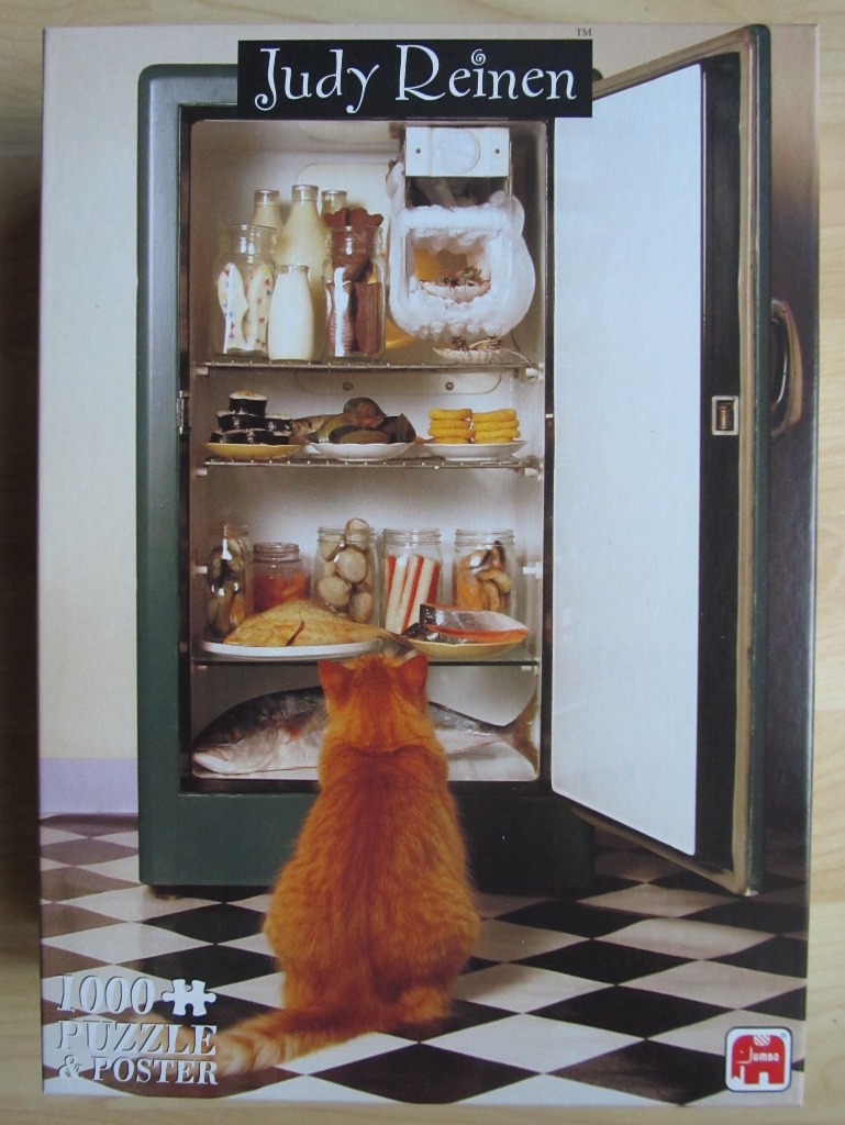 A ginger cat sitting in front of an open, vintage-style refrigerator stocked with food.