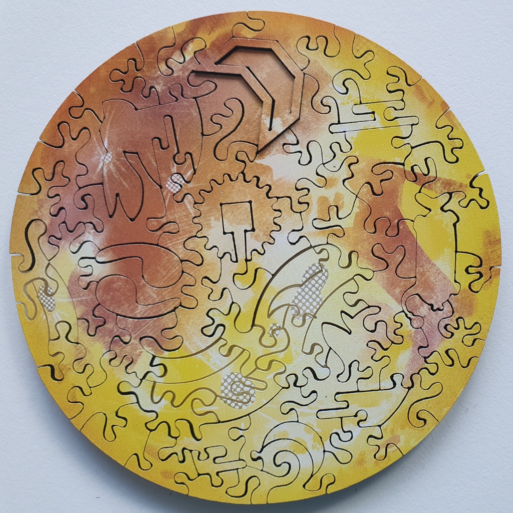A circular abstract design featuring warm yellow, orange, and tan watercolor-style washes with geometric cutouts.