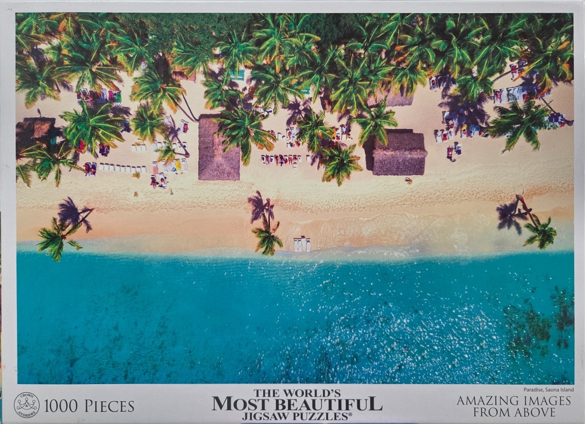 Aerial view of a tropical sandy beach with palm trees, thatched-roof huts, and turquoise water.
