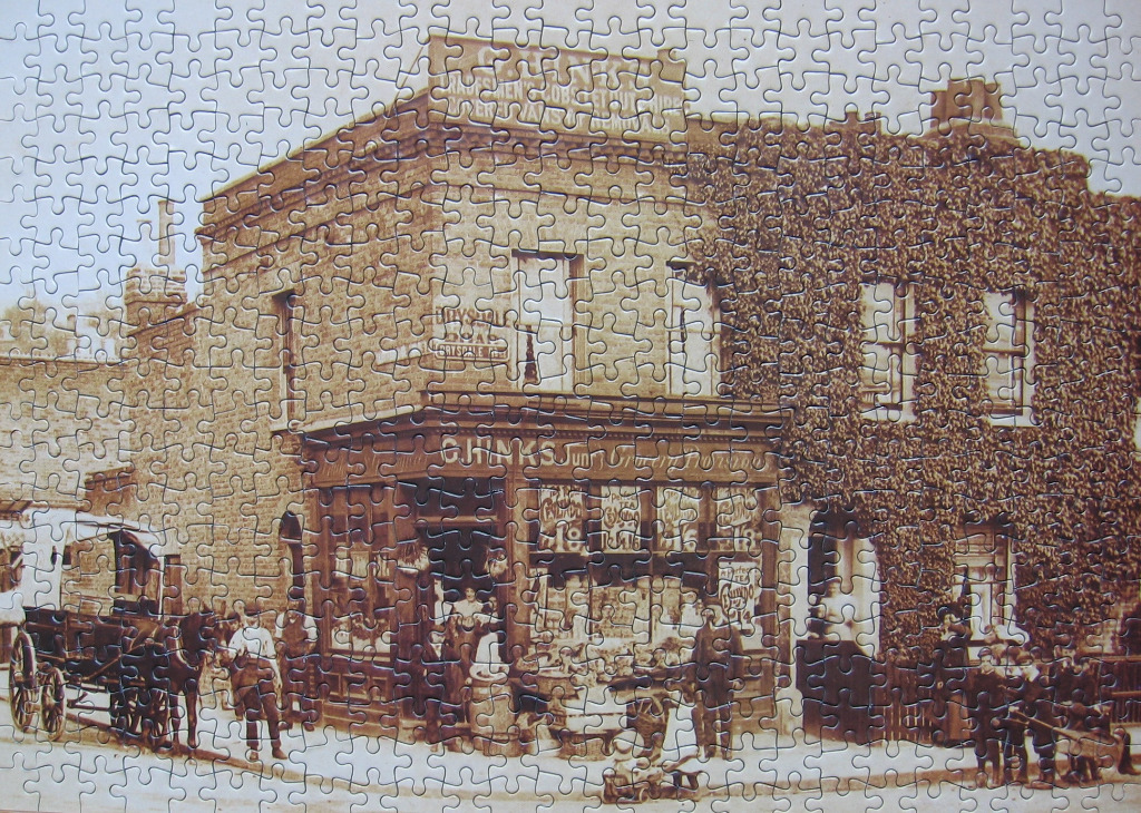 A vintage sepia-toned photograph of a corner grocery store with a horse-drawn carriage in front.