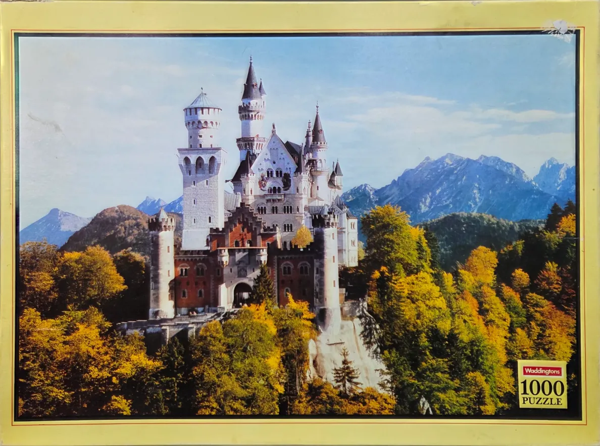 A scenic photograph of Neuschwanstein Castle in Bavaria, Germany, surrounded by vibrant autumn trees and mountains.