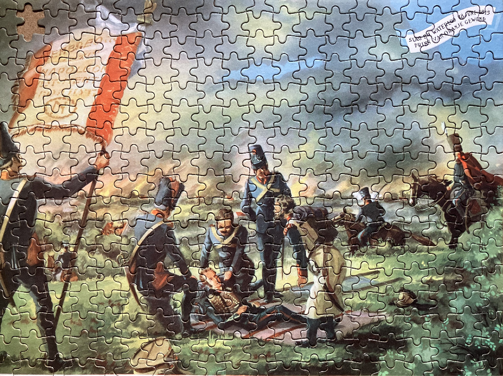 A historical illustration of soldiers tending to a wounded officer on a battlefield during the Battle of Waterloo.