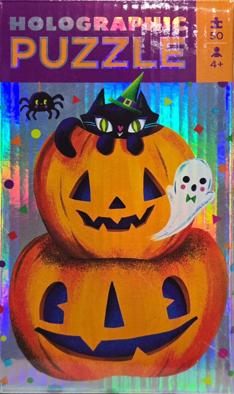 A black cat wearing a witch hat sits on a stack of two carved jack-o'-lanterns, surrounded by a ghost, a spider, and confetti