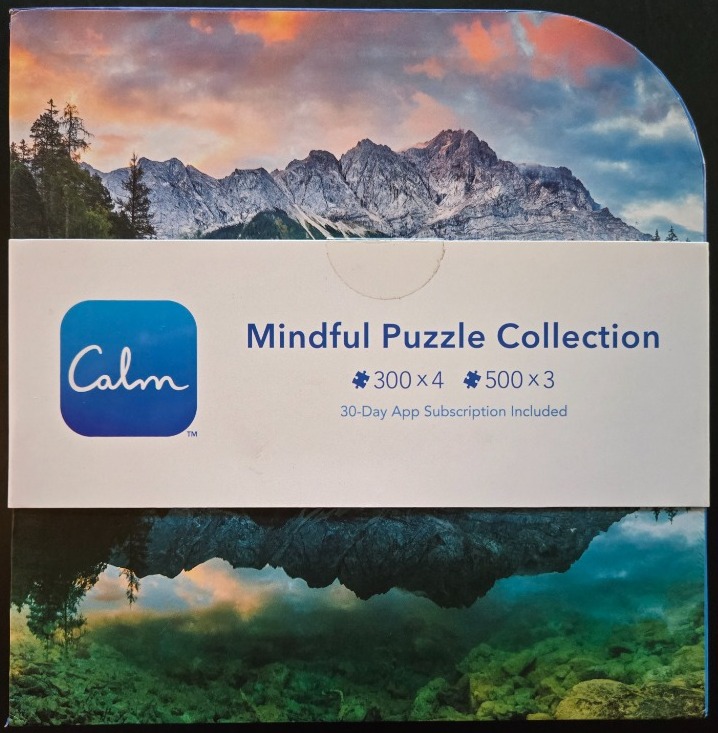 A scenic mountain landscape reflected in a calm lake at sunset