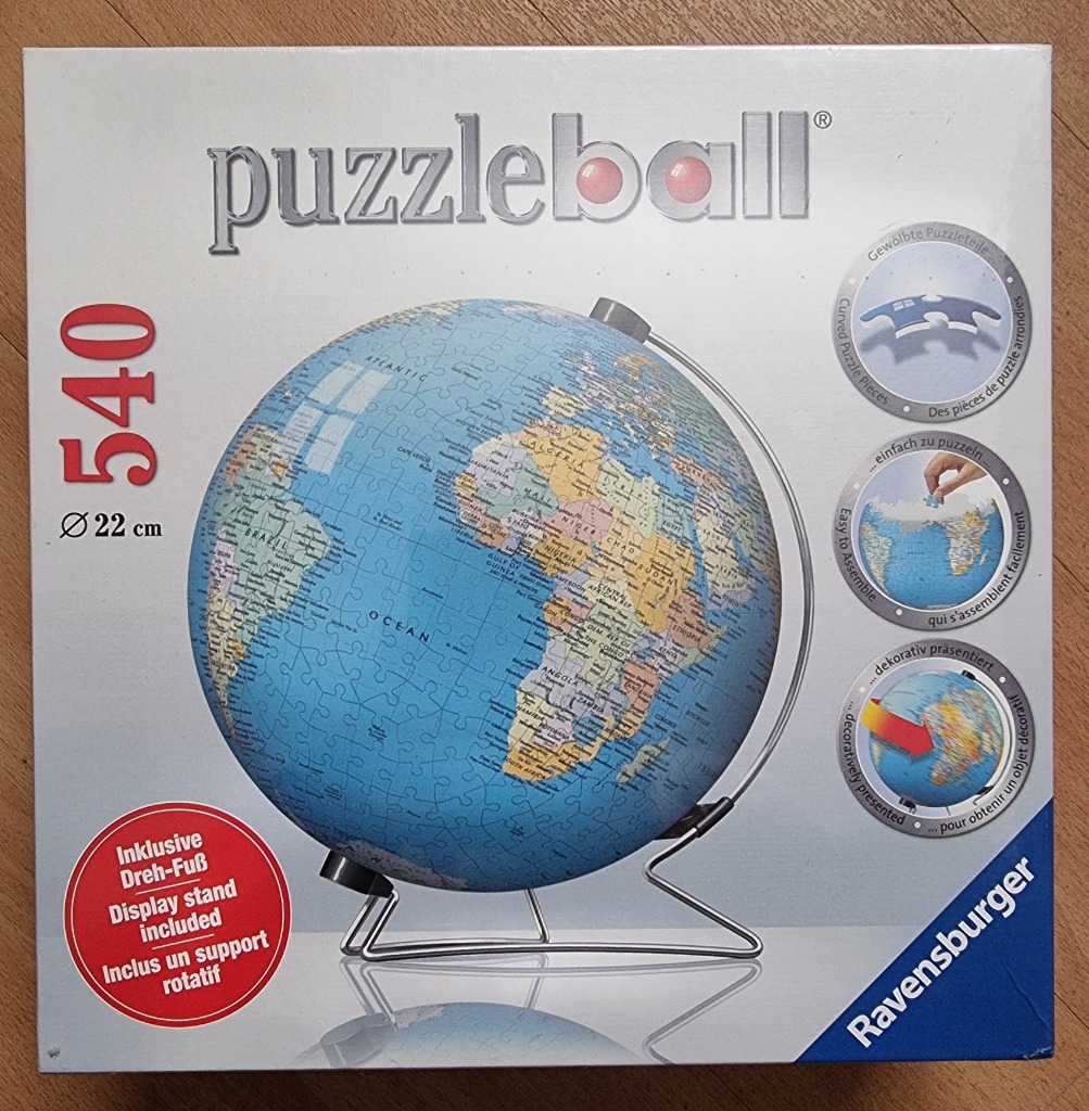A spherical world globe map mounted on a silver metal display stand.