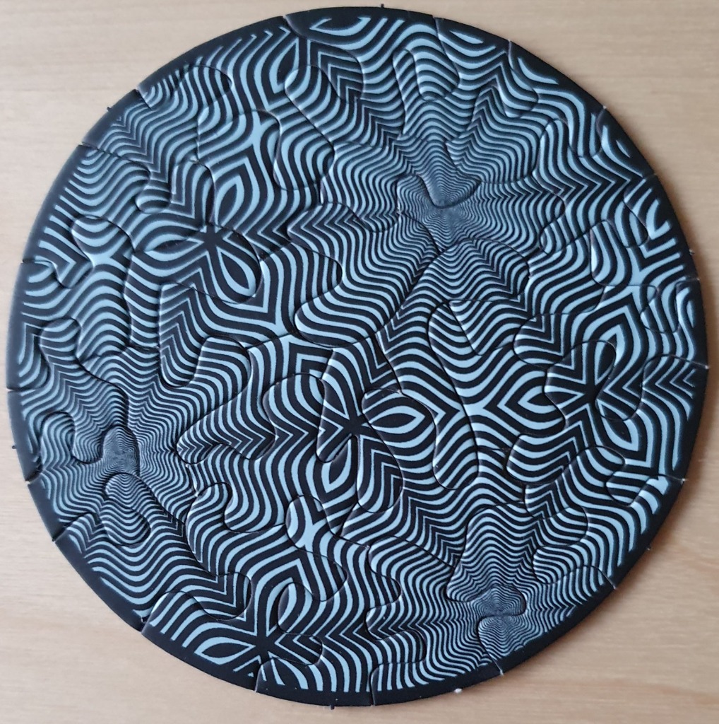 A circular op-art design featuring swirling black and white wavy lines that create a three-dimensional effect.