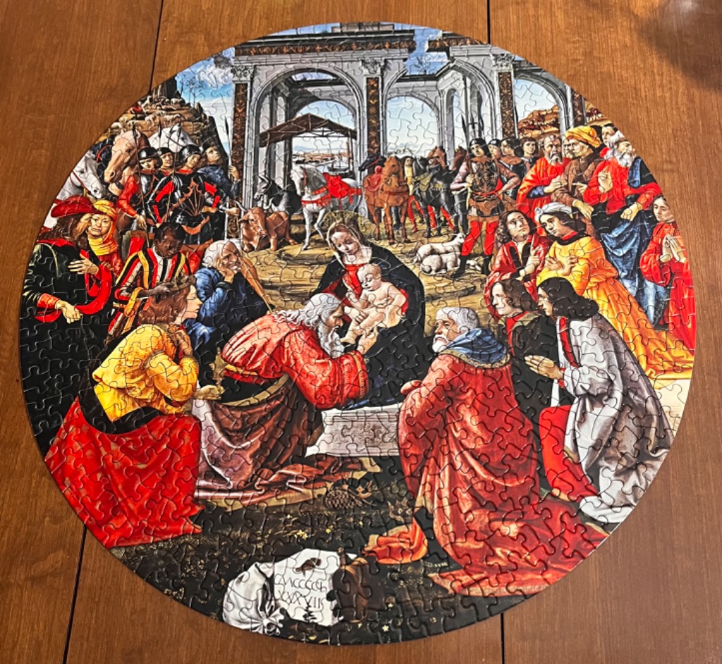 Circular Renaissance painting of the Adoration of the Magi showing the Virgin Mary, Christ child, and a crowd of figures.