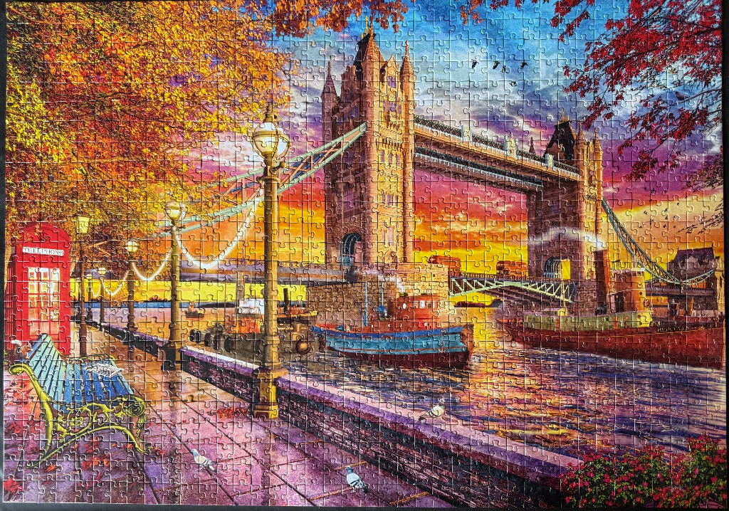 Tower Bridge in London during a vibrant sunset with a red phone booth in the foreground