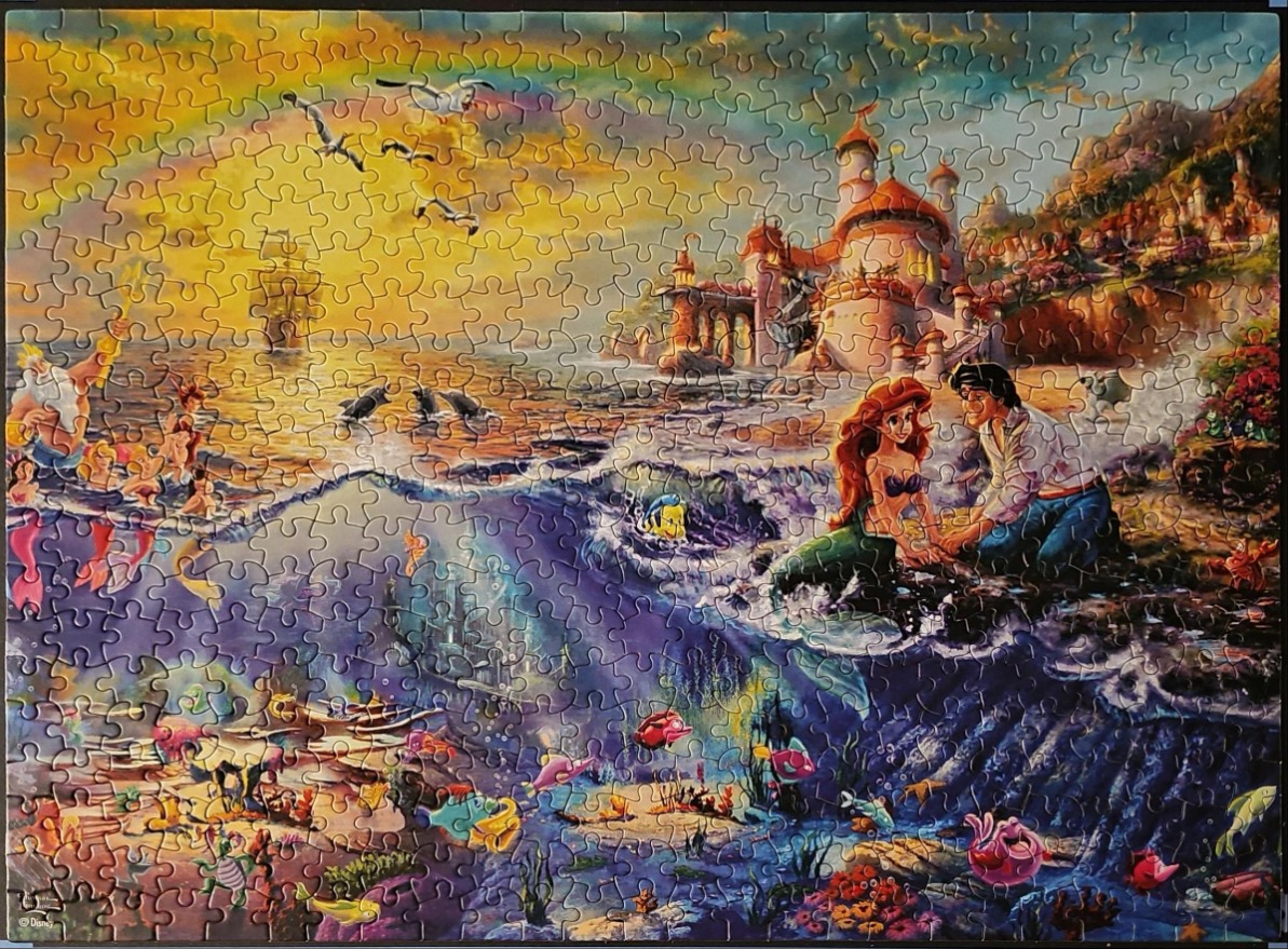 An illustration of The Little Mermaid characters and their underwater and surface worlds at sunset.