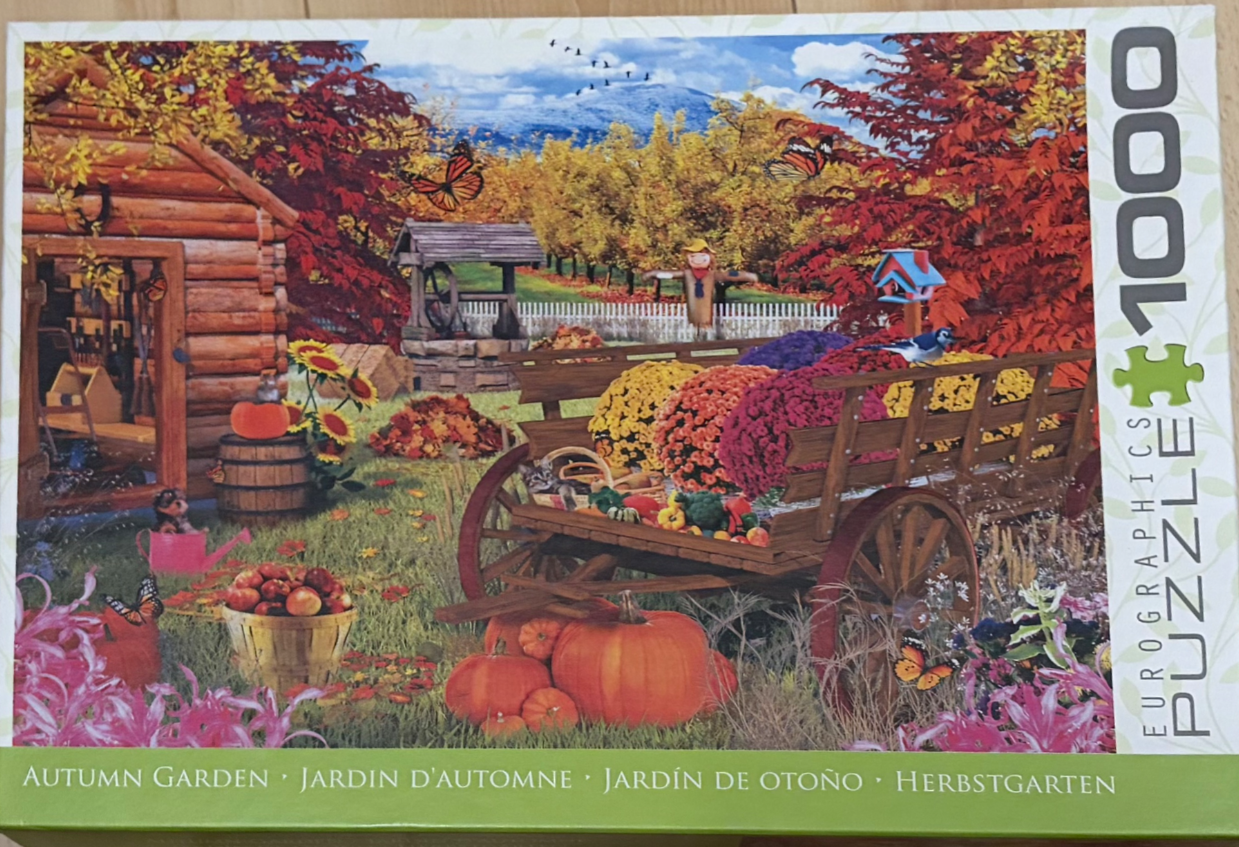 A lush autumn garden scene featuring a rustic wooden cart filled with colourful chrysanthemums and a small log cabin.