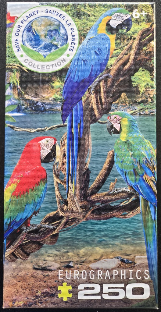 Three colorful macaws perched on gnarled branches in front of a tropical river and waterfall.