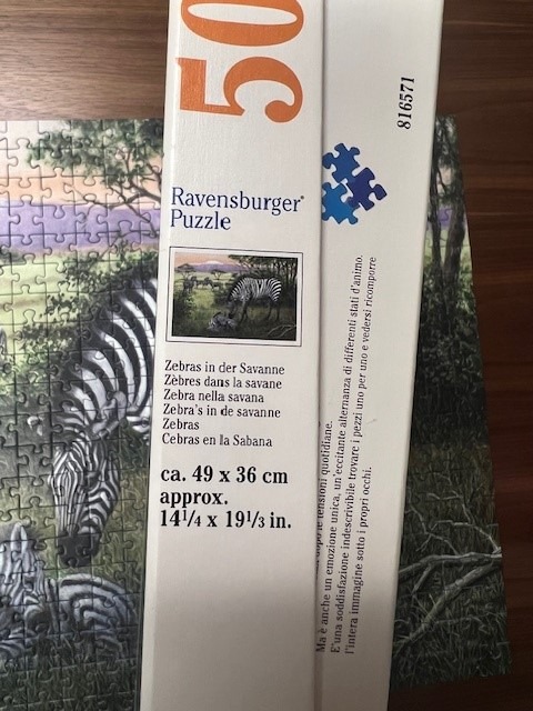 Zebras in a savanna scene with lush greenery and a soft purple sunset.