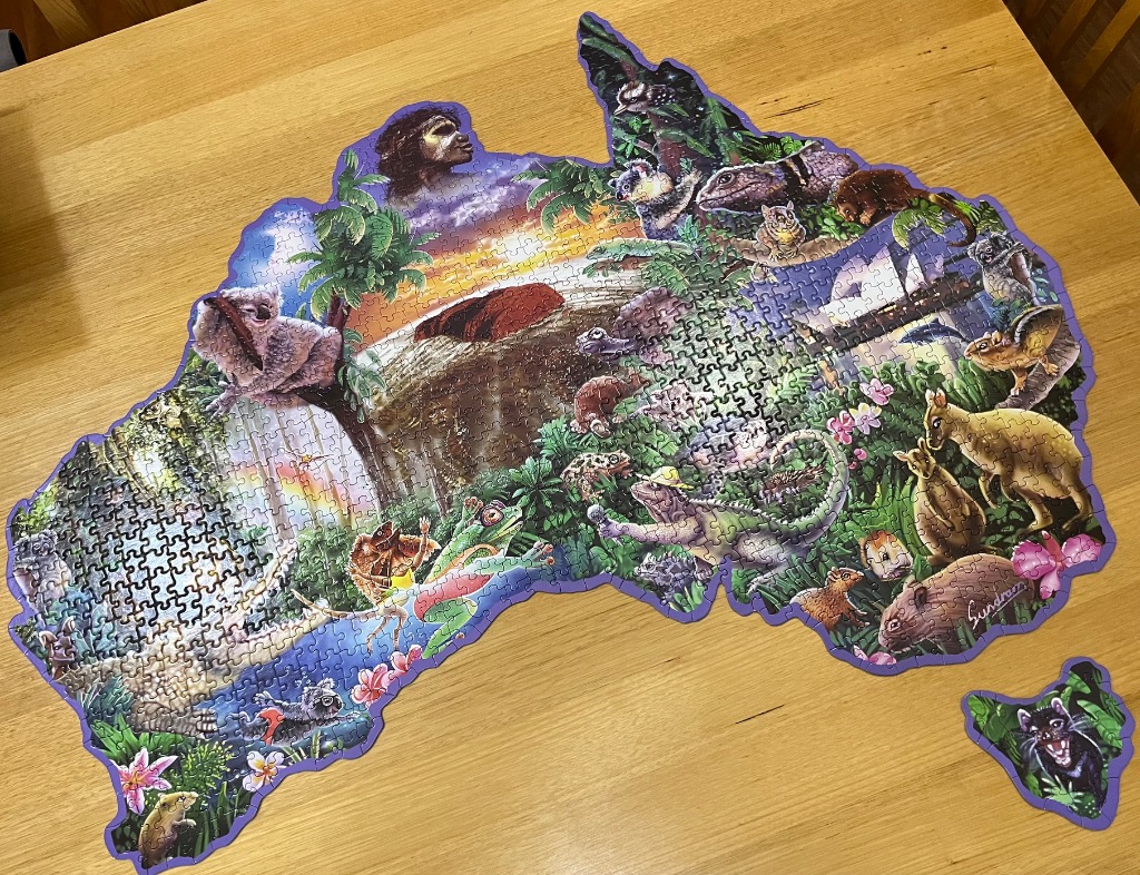 A shaped illustration of the map of Australia featuring diverse native wildlife and iconic landmarks.