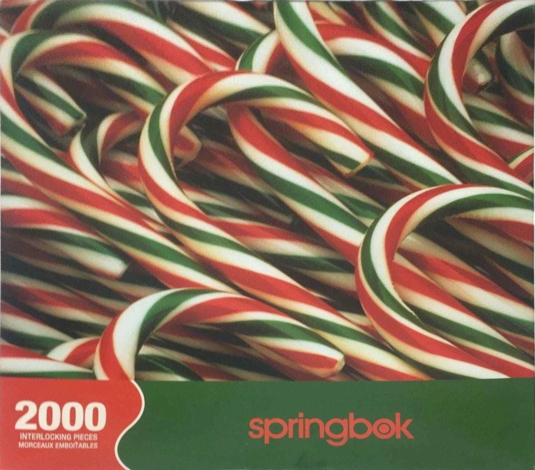 A close-up, high-angle view of a jumbled pile of red, white, and green striped candy canes.