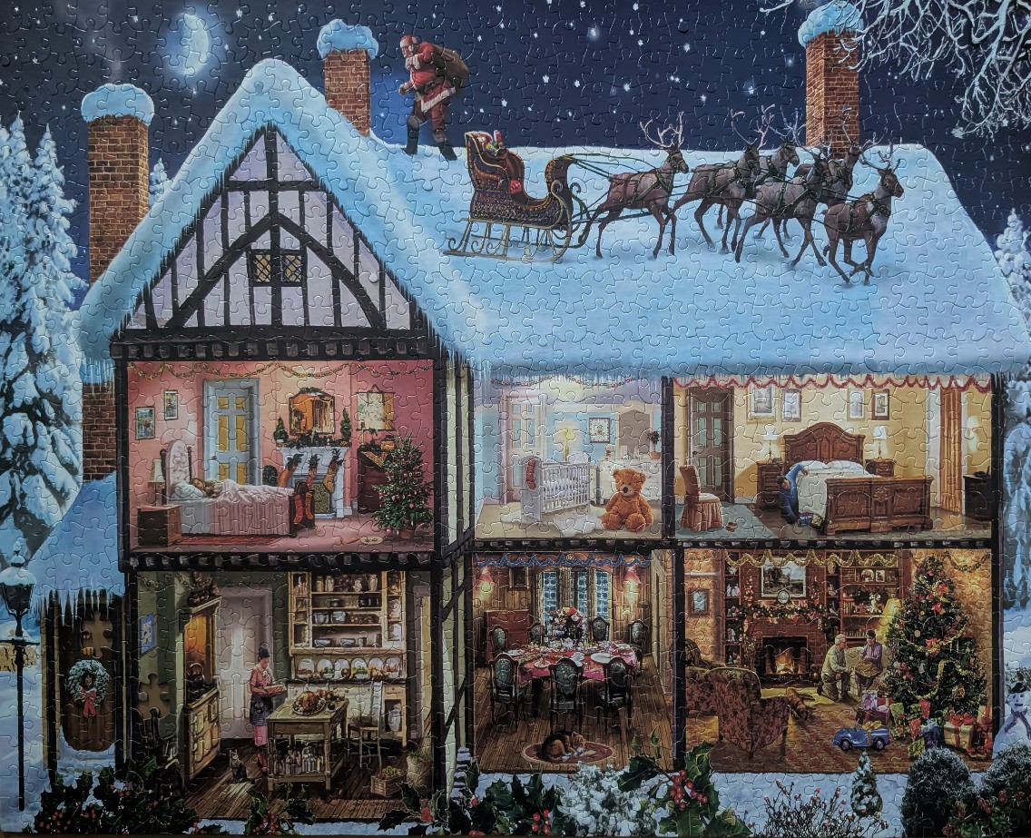 Cross-section of a snow-covered Tudor house at night with Santa Claus and his reindeer on the roof.