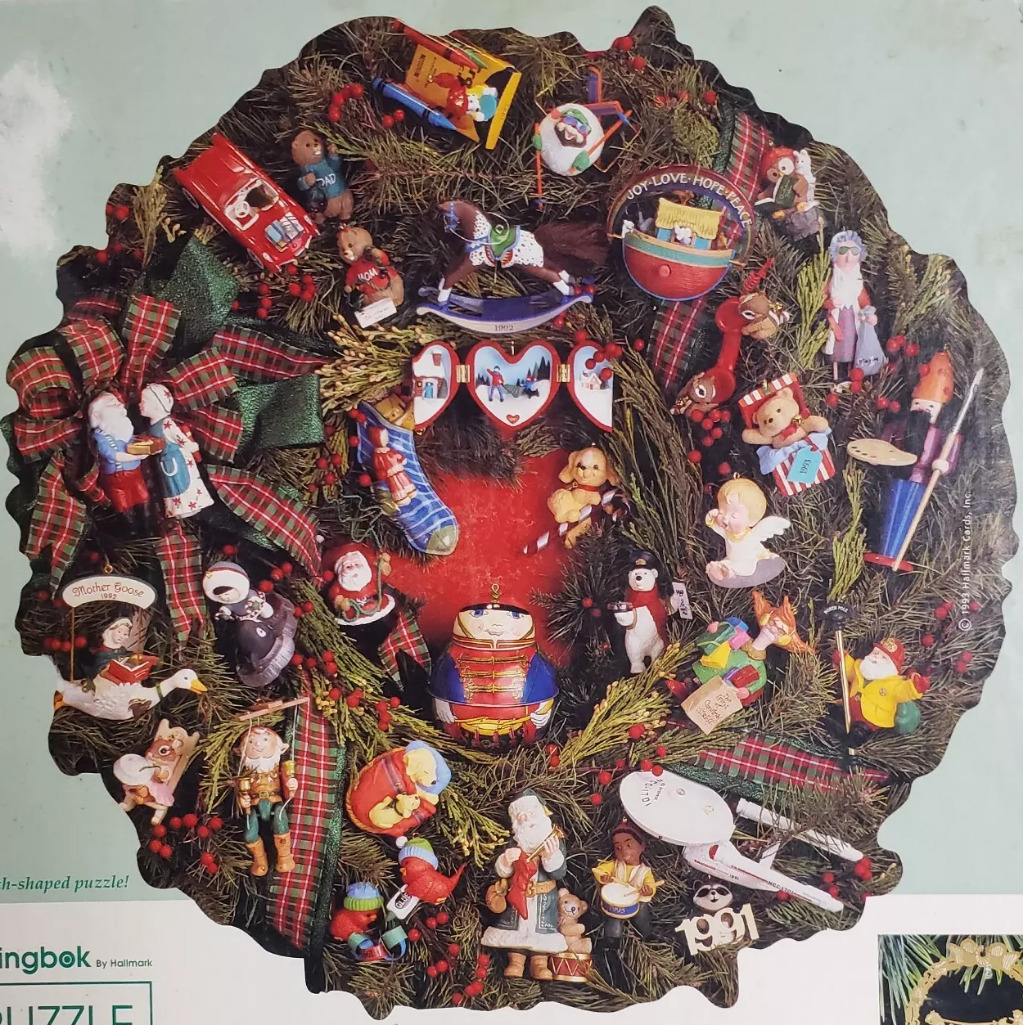 A lush pine wreath densely decorated with various Christmas-themed Hallmark Keepsake ornaments.