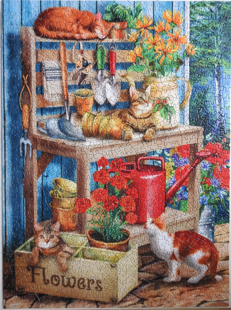 A cozy garden scene featuring a wooden potting bench, vibrant flowers, and three cats.