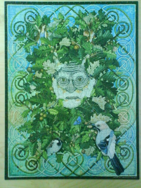 A whimsical illustration of a Green Man face formed by oak leaves surrounded by a Celtic knotwork border.