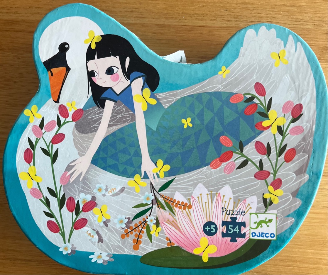 An illustration of a young girl with black hair sitting on the back of a large white swan among pink water lilies.