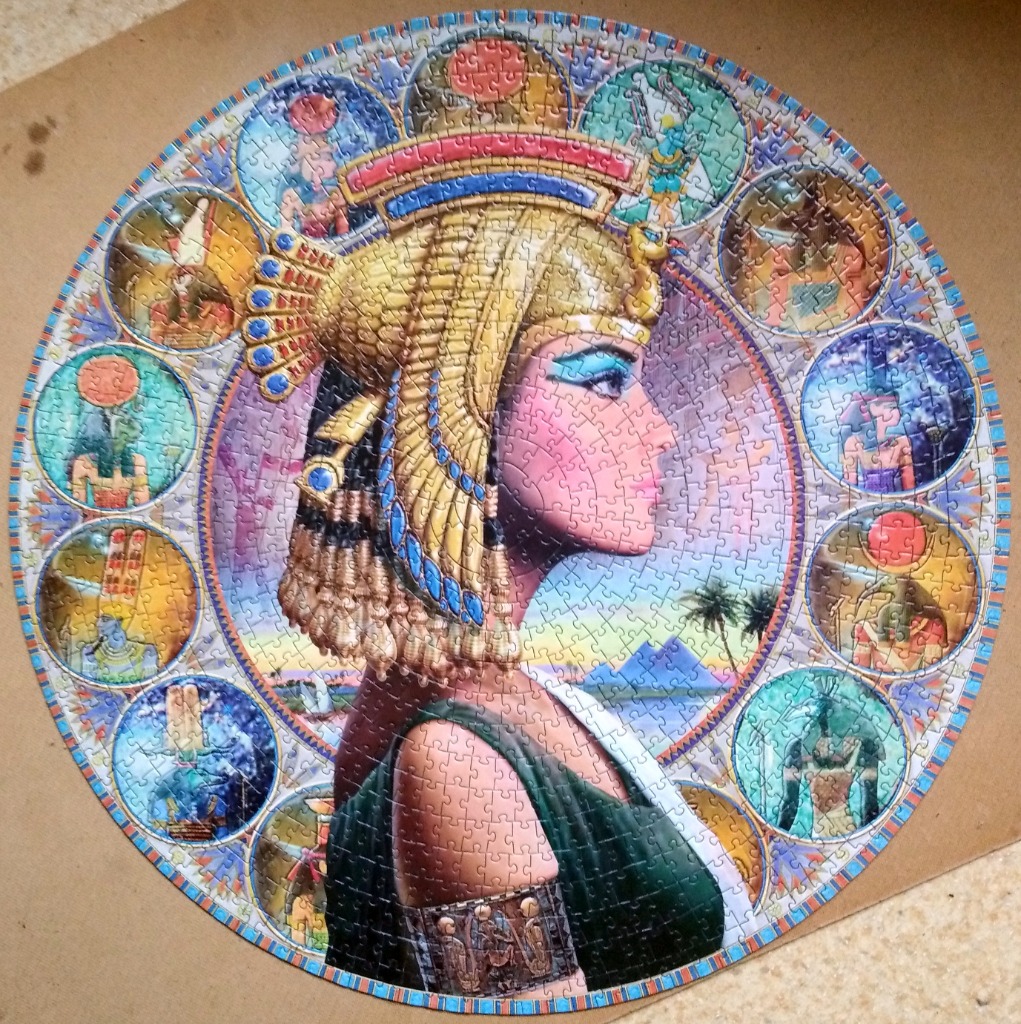 Circular illustration of Cleopatra in profile surrounded by a border of Egyptian deities in medallions.