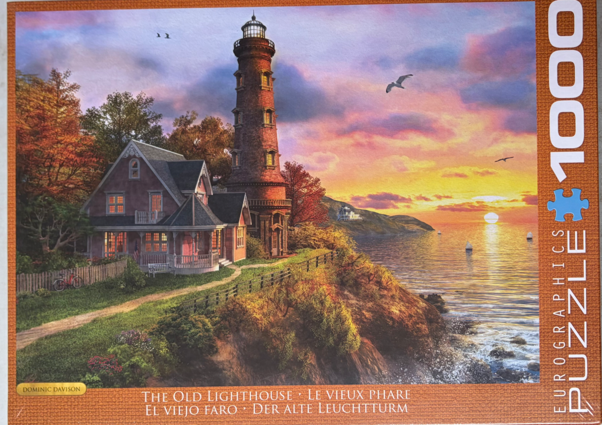 A lighthouse and victorian home overlooking the ocean at sunset