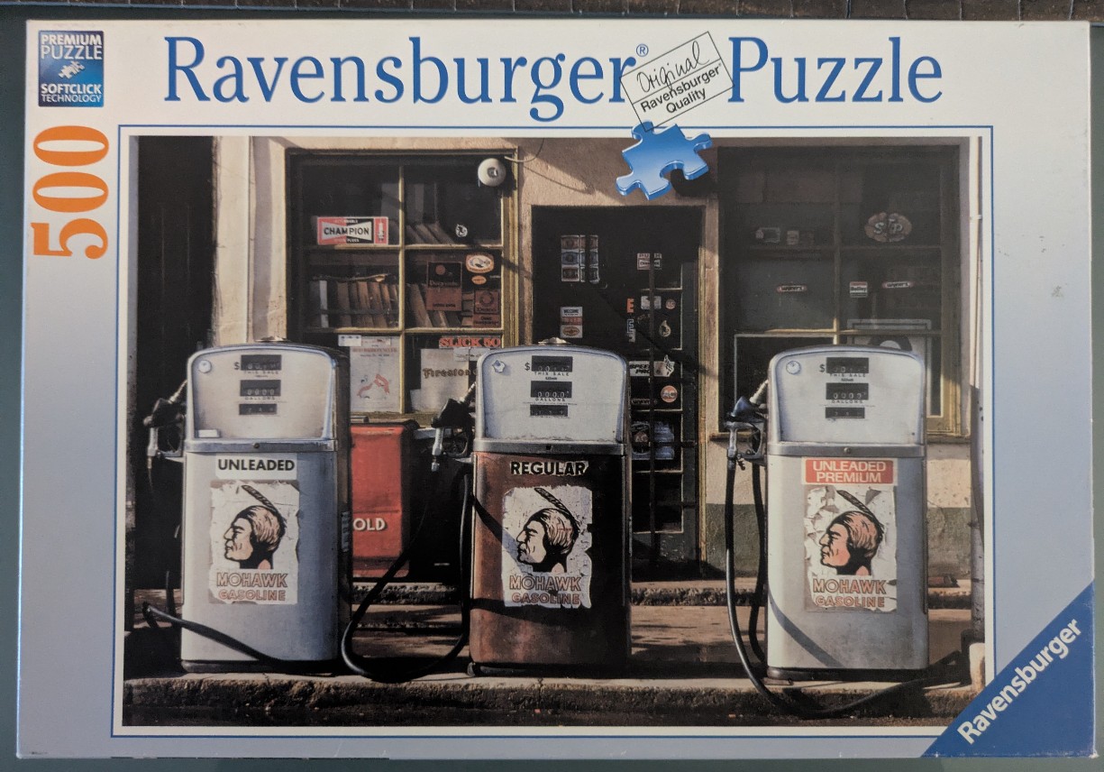 Three vintage, weathered Mohawk Gasoline pumps in front of an old service station building.