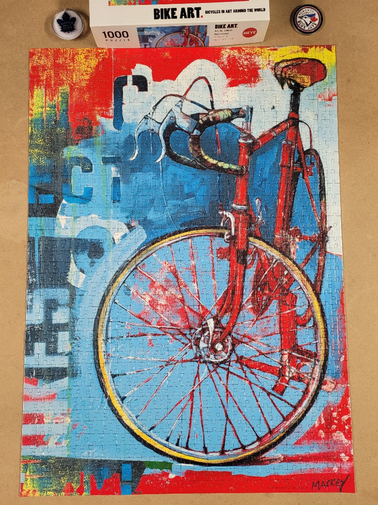 An artistic illustration of a red racing bicycle set against a vibrant, abstract background of blue, red, and yellow.