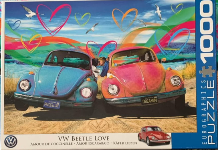 Two classic Volkswagen Beetles parked on a beach with a couple kissing between them, decorated with vibrant rainbow hearts.
